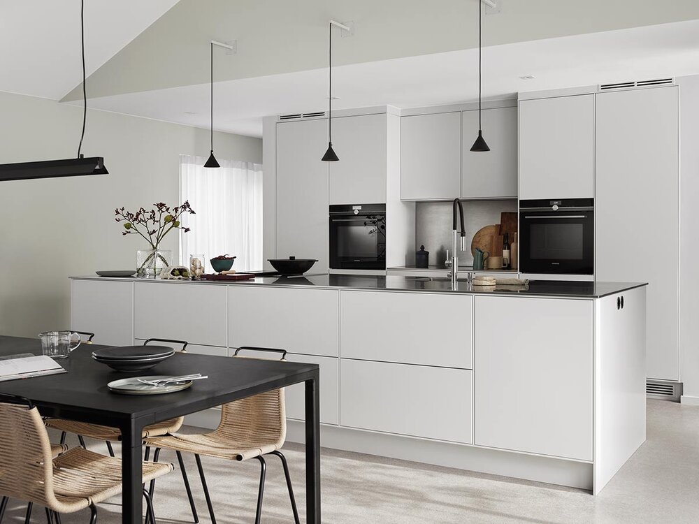 Lys grått kjøkken med benkeplate av rustfritt stål