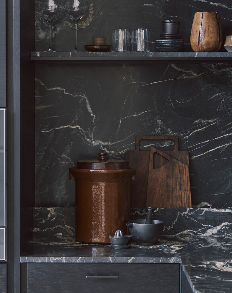 Benkeplate og backsplash i svart marmor med svart kjøkkeninnredning